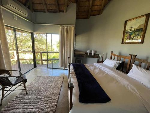 a bedroom with a bed and a large window at Mpofu Lodge in Bergview