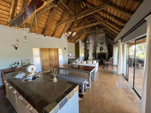 a kitchen and living room with wooden ceilings and a table at Mpofu Lodge in Bergview