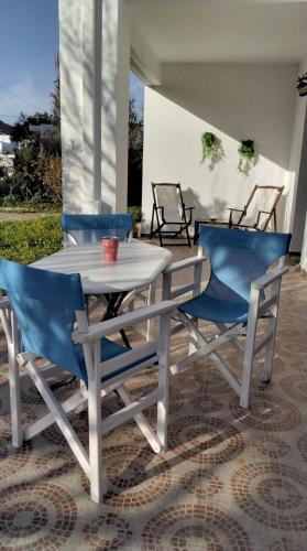 a white table and two blue chairs on a patio at Anna's Apartment in Galissas