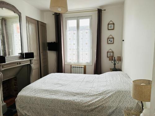 1 dormitorio con cama blanca y ventana en Maison Ma Bohème, 250m de la mer, en Cayeux-sur-Mer