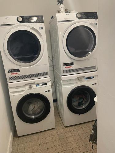 2 wasmachines en een droger in een kamer bij Appartement gare du midi in Brussel