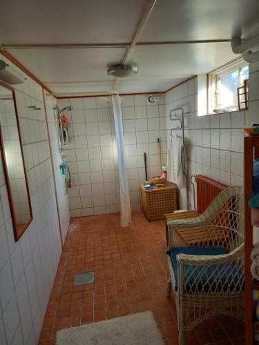 a bathroom with a shower and a tiled floor at Ljust boende, egen ingång och trädgård i centrum in Varberg