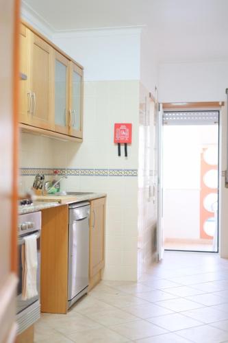 a kitchen with a sink and a door to a bathroom at Casa da Maria Baleal com Piscina, Ténis e 5min da Praia in Ferrel