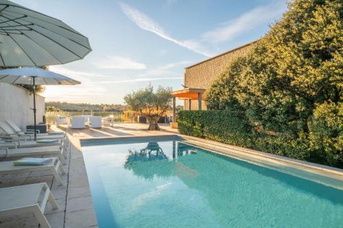 une piscine avec des chaises et un parasol dans l'établissement Le Répertoire - Maison Marc, à Venasque