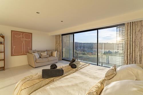 - une chambre avec un lit, un canapé et une grande fenêtre dans l'établissement Le Répertoire - Maison Marc, à Venasque