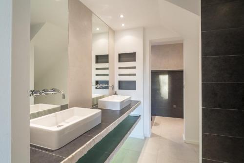 une salle de bain avec deux lavabos et un grand miroir dans l'établissement Le Répertoire - Maison Marc, à Venasque