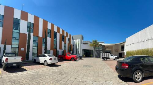 a parking lot with cars parked in front of a building at Hotel Brisas Express in San Cristóbal de Las Casas