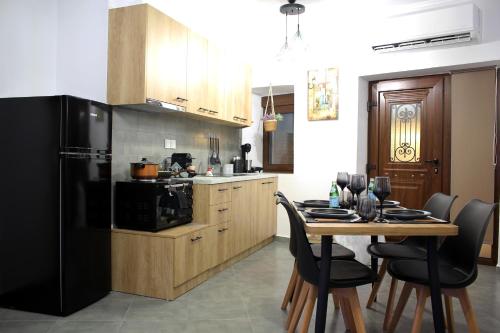 a kitchen with a table and a black refrigerator at Center Of Elegance in Xanthi