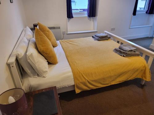 a bedroom with a bed with yellow sheets and pillows at the devon and cornwall inn in Millbrook