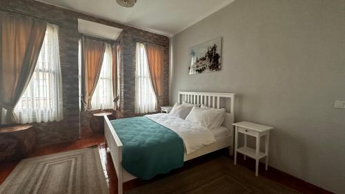 a bedroom with a bed and two windows at Lia Suit Beşiktaş in Istanbul