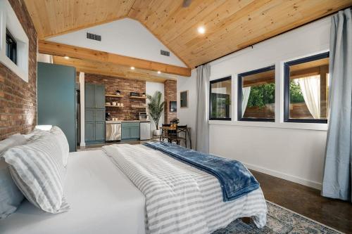 um quarto com uma cama grande e uma parede de tijolos em Petit Paradis Studio with hot tub em Fredericksburg