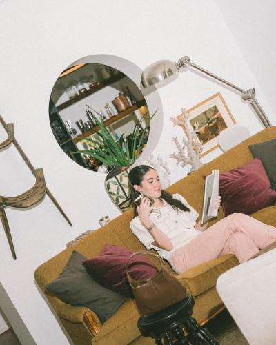 a woman sitting on a couch in front of a mirror at Fausto by Andean in Lima