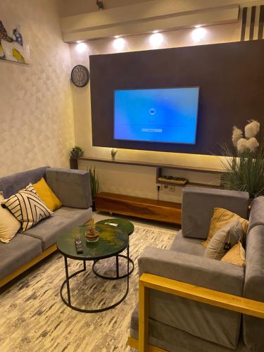 a living room with two couches and a large screen tv at Emefa Room in Cotonou