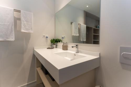 uma casa de banho branca com um lavatório e um espelho em Apartamentos 7 dreams em Málaga