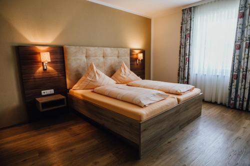 a bedroom with a bed with a headboard and a window at Zum Alten Wirt in Mauern