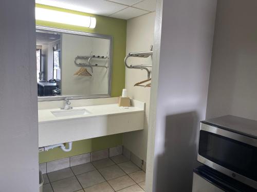łazienka z umywalką, lustrem i telewizorem w obiekcie Blue Stone Inn w mieście Washington Court House