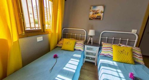 ガンディアにあるGandiazar Playa Gandiaの黄色と青色のドミトリールーム ベッド2台