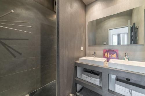 une salle de bain avec deux lavabos et une douche dans l'établissement L'Olympe - triplex avec spa et rooftop Classé 4*, à La Rochelle