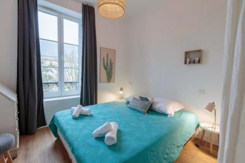 une chambre avec un lit bleu avec des serviettes dessus dans l'établissement L'Olympe - triplex avec spa et rooftop Classé 4*, à La Rochelle