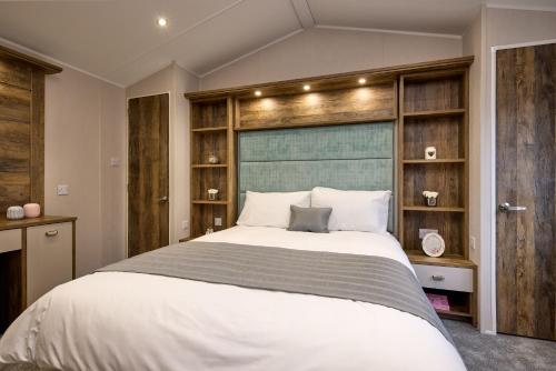 a bedroom with a large bed with wooden shelves at Seaton Estate in Arbroath