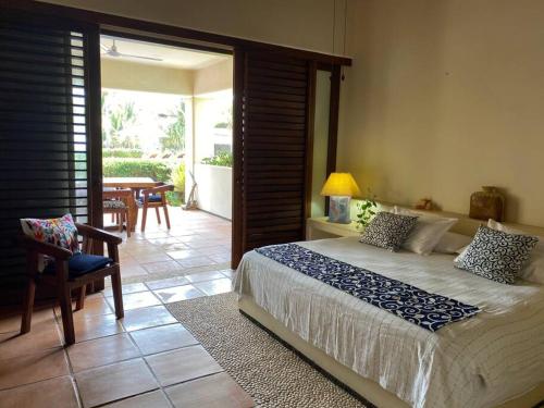 - une chambre avec un lit et une terrasse avec une table dans l'établissement Villa Caracol in Las Palmas Luxury Villas, à Barra de Potosi