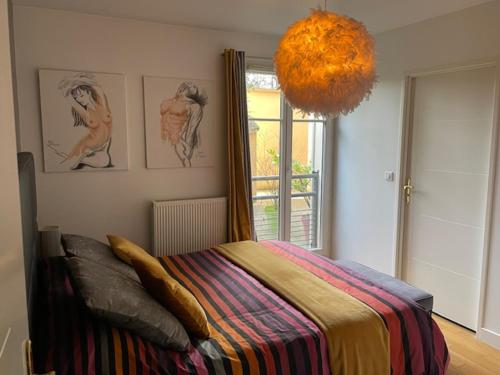 - une chambre avec un lit et une couverture colorée dans l'établissement appartement + jardin privatif, à Versailles