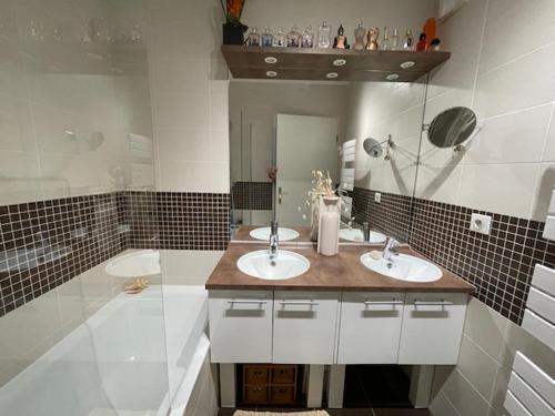 une salle de bain avec deux lavabos et un miroir dans l'établissement appartement + jardin privatif, à Versailles