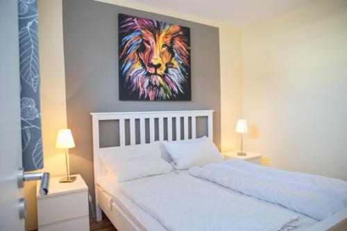 ein Schlafzimmer mit einem Bett mit einem Löwengemälde in der Unterkunft Fürstenhof Whg 108 inkl WLAN in Grömitz