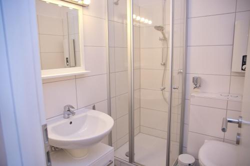 ein Bad mit einem Waschbecken und einer Dusche in der Unterkunft Fürstenhof Whg 108 inkl WLAN in Grömitz