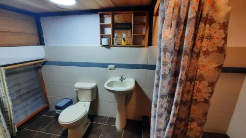 a small bathroom with a toilet and a sink at Alma de cedrela in Puerto Ayora