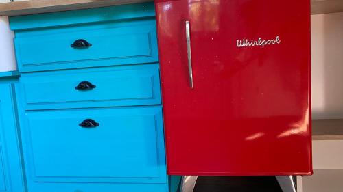a red refrigerator next to some blue dresser at Cabaña en el corazón de City Bell in City Bell