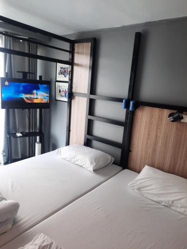 a bedroom with a bed and a flat screen tv at SLEEP TO FLY HOTEL & HOSTEL suvarnabhumi airport in Bangkok