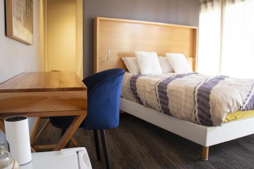 une chambre avec un lit, un bureau et une table dans l'établissement Sol'm Villa, à Solesmes