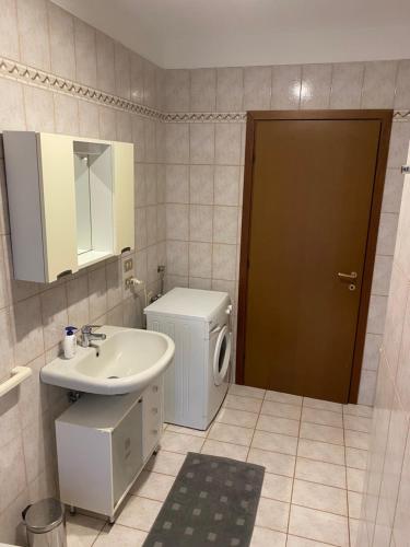 uma casa de banho com um lavatório e uma máquina de lavar roupa em Appartamento ONE em Novara