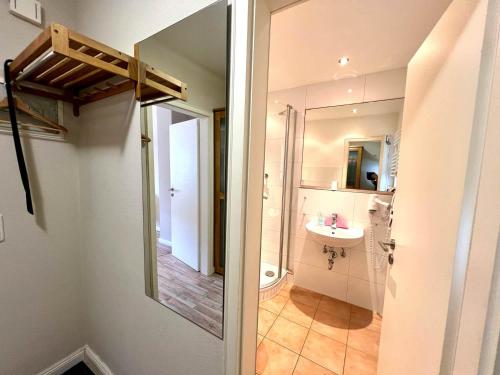 een badkamer met een douche, een wastafel en een spiegel bij Ferienwohnung Mare Nostrum 6 in Westerland