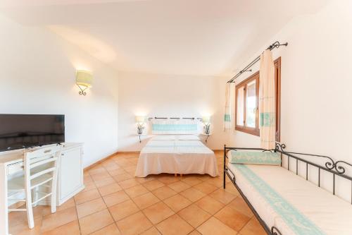 1 dormitorio con 2 camas y TV. en Résidence Pierre & Vacances Vignola Mare en Vignola Mare