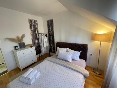 a bedroom with a bed and a dresser at Charme apartman in Kruševac