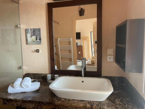 een badkamer met een wastafel en een grote spiegel bij Villa vue mer et campagne in Essaouira
