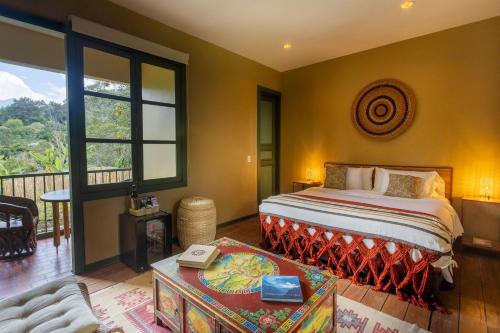 a bedroom with a bed and a balcony at Sazagua Cocora Reserva Natural in Salento