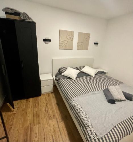 a bedroom with two beds and a black cabinet at Trevi u Liku in Gospić