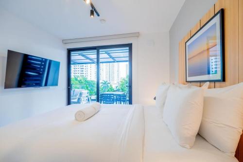 a white bedroom with a white couch and a window at San Francisco by Wynwood House in Panama City