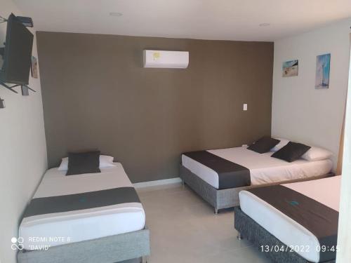 1 dormitorio con 2 camas y TV. en HOTEL ARRECIFE, en Santa Verónica
