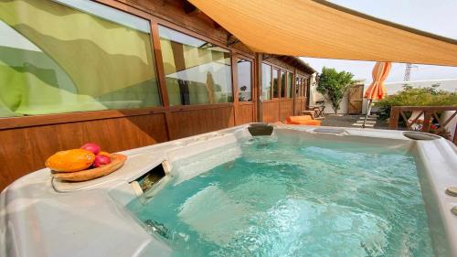 a hot tub with a bowl of fruit in it at Casita Mis Chinijos con Jacuzzi o Minipiscina in La Asomada
