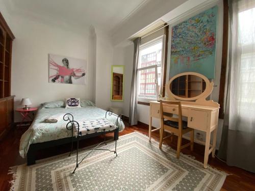 a bedroom with a bed and a desk and a mirror at Habitación Céntrica in A Coruña