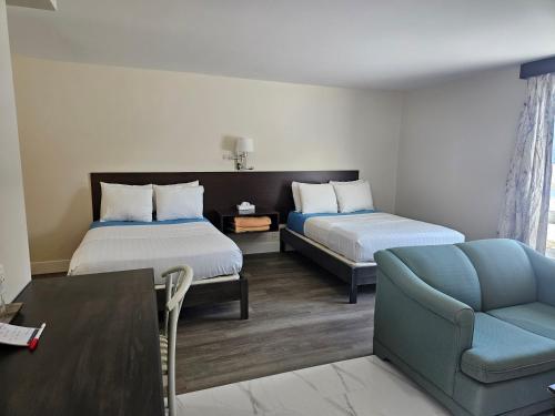 pokój hotelowy z 2 łóżkami i kanapą w obiekcie Leelas Villa Inn Flesherton w mieście Flesherton