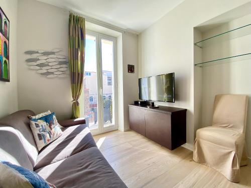 un salon avec un canapé et une télévision à écran plat dans l'établissement Le 74 By SCLS Locations, à Cannes