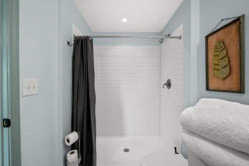 ein weißes Bad mit einer Dusche und einem WC in der Unterkunft Historic Elegance Loft in Downtown Conway in Conway