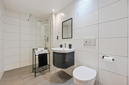 a white bathroom with a toilet and a sink at Stunning 2 Bed basement flat in Hammersmith in London