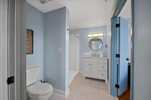 a bathroom with a white toilet and a sink at Discover Conway Trendy Downtown Loft in Conway