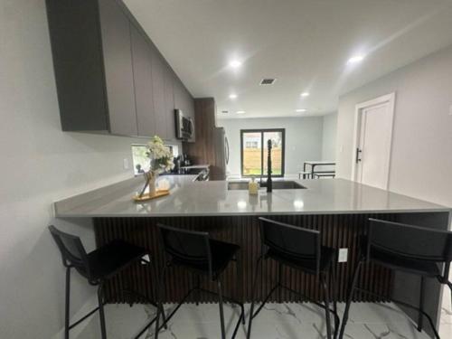 Una cocina con una isla con sillas. en Luxe 3 bed & 3 bath Minutes from Design district, en Miami